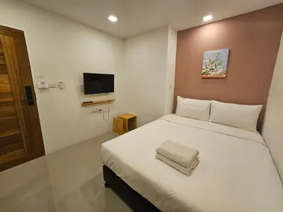 a bedroom with a white bed and a flat screen tv at Sleepstation at Pratunam in Bangkok