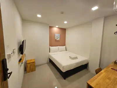 a small room with a bed and a tv at Sleepstation at Pratunam in Bangkok