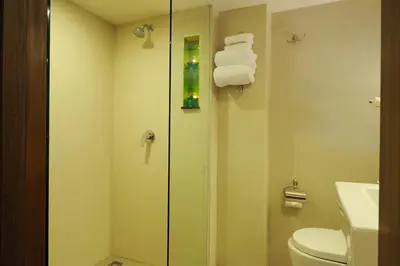 a bathroom with a shower and a toilet and towels at 41 Suite Bangkok in Bangkok