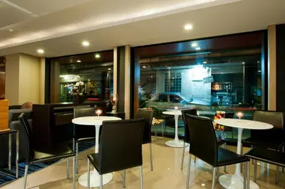 a restaurant with tables and chairs and a car in the window at 41 Suite Bangkok in Bangkok