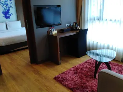 a room with a bed and a desk with a television at 41 Suite Bangkok in Bangkok