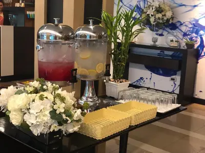 a table with flowers and two large vases with drinks at 41 Suite Bangkok in Bangkok