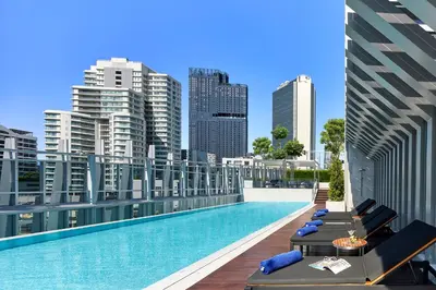 a swimming pool on the roof of a building with a city at Somerset Maison Asoke Bangkok in Bangkok