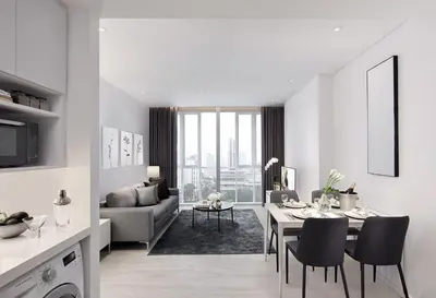 a white living room with a table and a couch at Somerset Maison Asoke Bangkok in Bangkok
