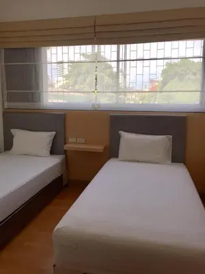two beds in a room with two windows at Nine Place Sukhumvit 40 in Bangkok