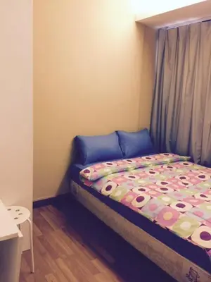 a small bedroom with a bed with a colorful comforter at Nine Place Sukhumvit 40 in Bangkok