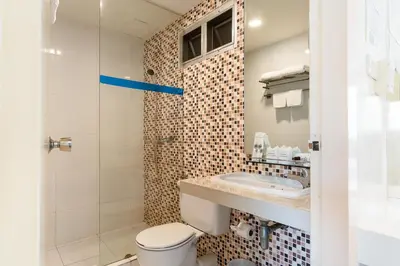 a bathroom with a toilet and a sink and a shower at Summit Pavilion Hotel in Bangkok