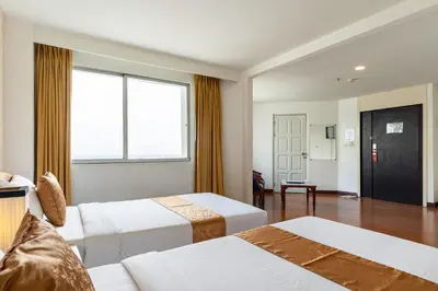 a hotel room with two beds and a window at Summit Pavilion Hotel in Bangkok