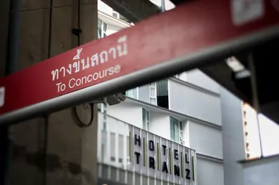 a red street sign in front of a building at Hotel Tranz in Bangkok