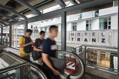 a group of people walking down an escalator at Hotel Tranz in Bangkok
