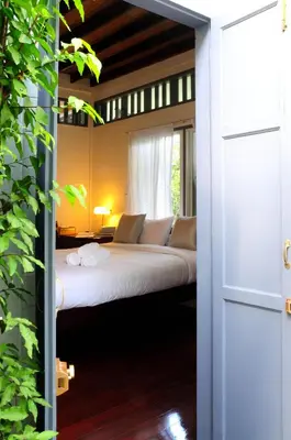 a bedroom with a bed with a window at Baan Noppawong in Bangkok