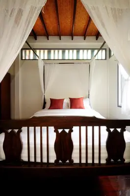 a bedroom with a bed with red pillows at Baan Noppawong in Bangkok