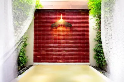 a red brick wall with a light in a window at Baan Noppawong in Bangkok