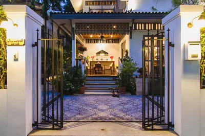 an open gate to a house with a dining room at Baan Noppawong in Bangkok