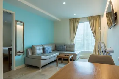 a living room with a couch and a table at Sabai Sathorn Service Apartment in Bangkok