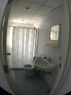 a bathroom with a sink and a toilet and a mirror at Roof View Place in Bangkok
