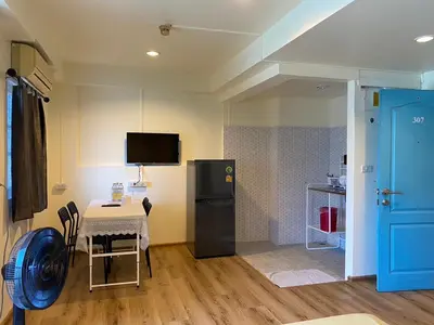 a small kitchen with a table and a refrigerator at Roof View Place in Bangkok