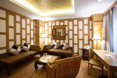 a living room with a couch and a table at The Tarntawan Hotel Surawong Bangkok in Bangkok