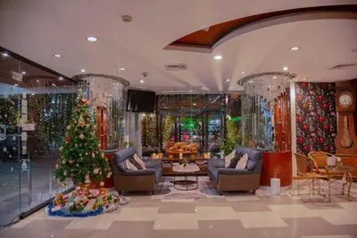 a christmas room with a christmas tree and chairs at The Sunreno Hotel Bangkok in Bangkok