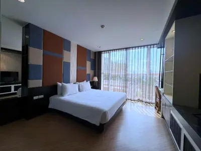 a bedroom with a bed and a large window at The Sunreno Hotel Bangkok in Bangkok
