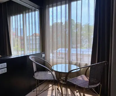 a table and chairs in a room with a window at The Sunreno Hotel Bangkok in Bangkok