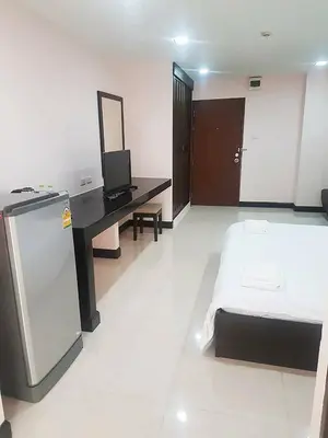 a bedroom with a bed and a desk with a mirror at Mok Mek 72 in Bangkok