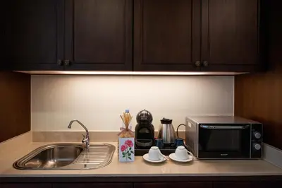 a kitchen counter with a sink and a microwave at The Rose Residence, Bangkok in Bangkok