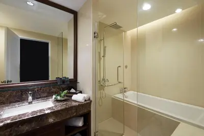 a bathroom with a shower and a sink and a tub at The Rose Residence, Bangkok in Bangkok