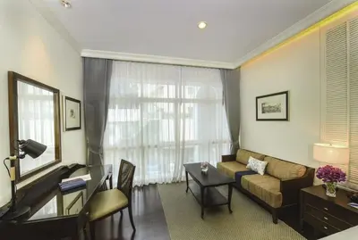 a living room with a couch and a table at The Rose Residence, Bangkok in Bangkok