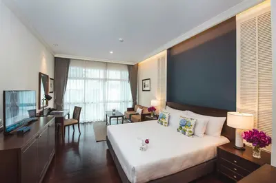 a hotel room with a large bed and a television at The Rose Residence, Bangkok in Bangkok