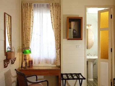 a bathroom with a window and a sink and a chair at Baan Dinso in Bangkok