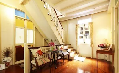 a room with a staircase with a table and chairs at Baan Dinso in Bangkok