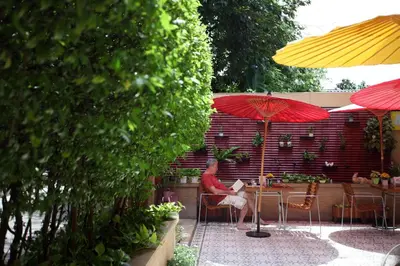 a man sitting at a table under an umbrella at Baan Dinso in Bangkok