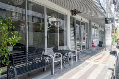 a table and chairs sitting outside of a building at Ratchadamnoen Residence in Bangkok