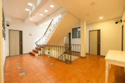 an empty room with a staircase in a house at Ratchadamnoen Residence in Bangkok