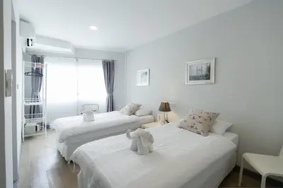 two beds with stuffed animals on them in a room at Ratchadamnoen Residence in Bangkok
