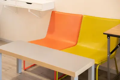 two colorful chairs sitting next to a table at Ratchadamnoen Residence in Bangkok