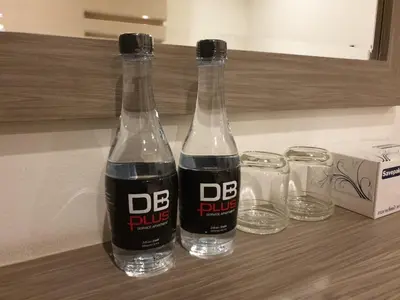 two bottles of soda sitting on a counter with glasses at DB Plus 2 in Bangkok