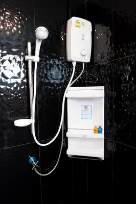 a shower with a white hose attached to a wall at DB Plus 5 in Bangkok