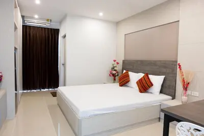 a bedroom with a white bed and a table at DB Plus 5 in Bangkok
