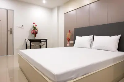 a bedroom with a large white bed with a large white bedspread at DB Plus 5 in Bangkok