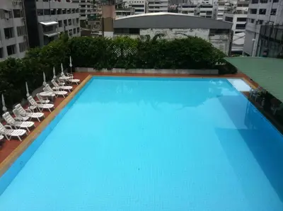 a large blue swimming pool on top of a building at Panoramic City View Room at Silom in Bangkok