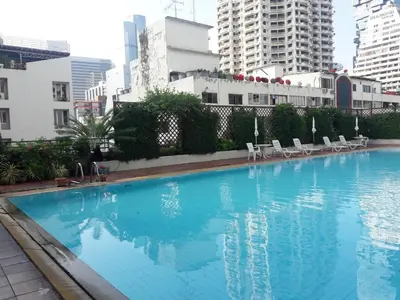 a large blue swimming pool in the middle of a city at Panoramic City View Room at Silom in Bangkok