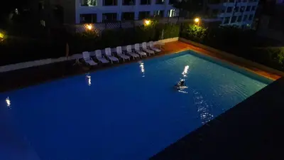 a person in a swimming pool at night at Panoramic City View Room at Silom in Bangkok