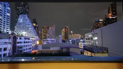 a view of a city skyline at night at Panoramic City View Room at Silom in Bangkok