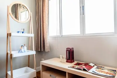 a bathroom with a sink and a mirror and a table at Nara Suite Residence Bangkok in Bangkok