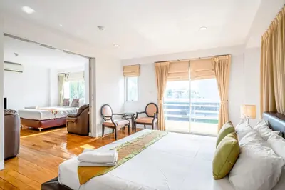 a bedroom with a bed and a table and chairs at Nara Suite Residence Bangkok in Bangkok