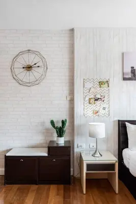 a bedroom with a bed and a clock on the wall at Nara Suite Residence Bangkok in Bangkok