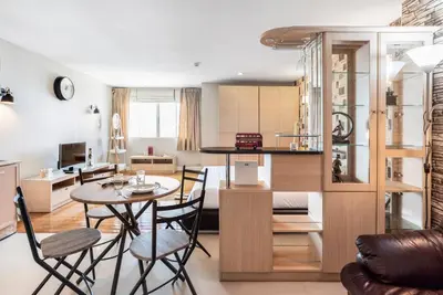 a kitchen and living room with a table and chairs at Nara Suite Residence Bangkok in Bangkok