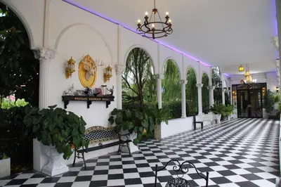 a room with a checkered floor with benches and plants at Westgate Residence Hotel in Ban Bang Kho